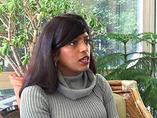 Woman in gray sweater speaking about melanoma