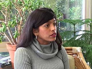 Woman in gray sweater speaking about melanoma