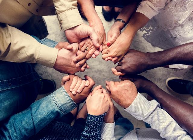 People of many races clasp hands in unity
