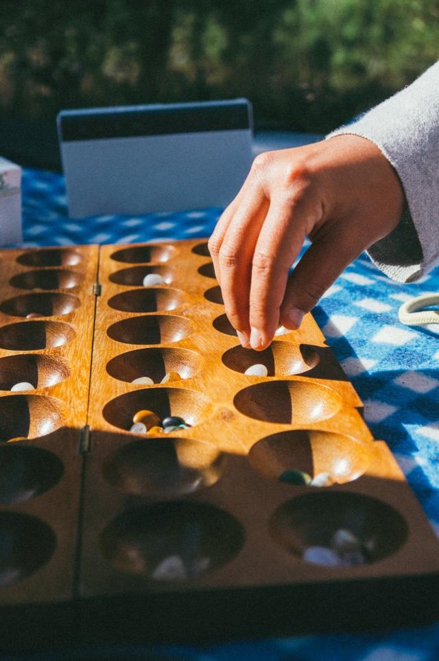 image of hand hovering over a mandala with beads