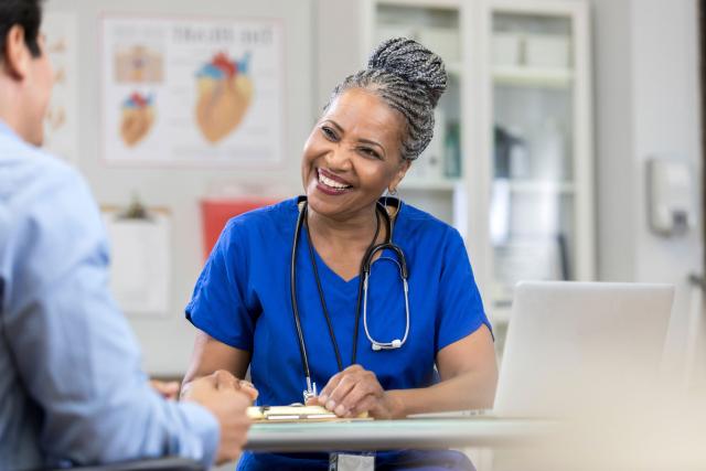 A female doctor smiling from behind a table