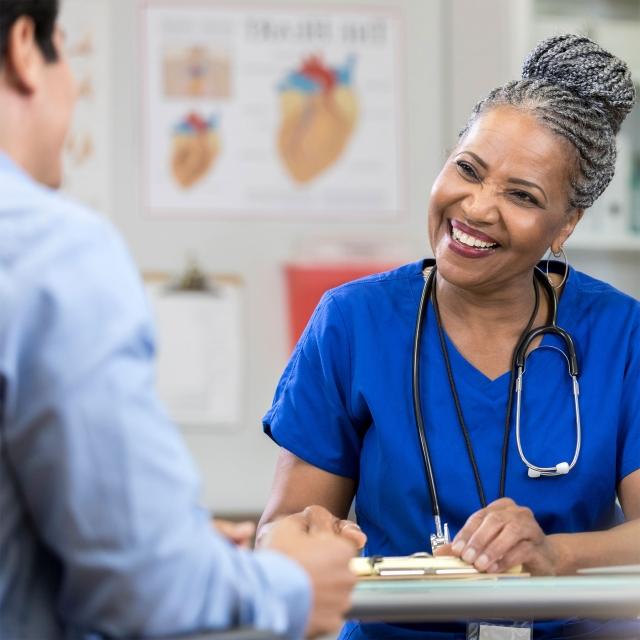 a smiling doctor sitting behind a table