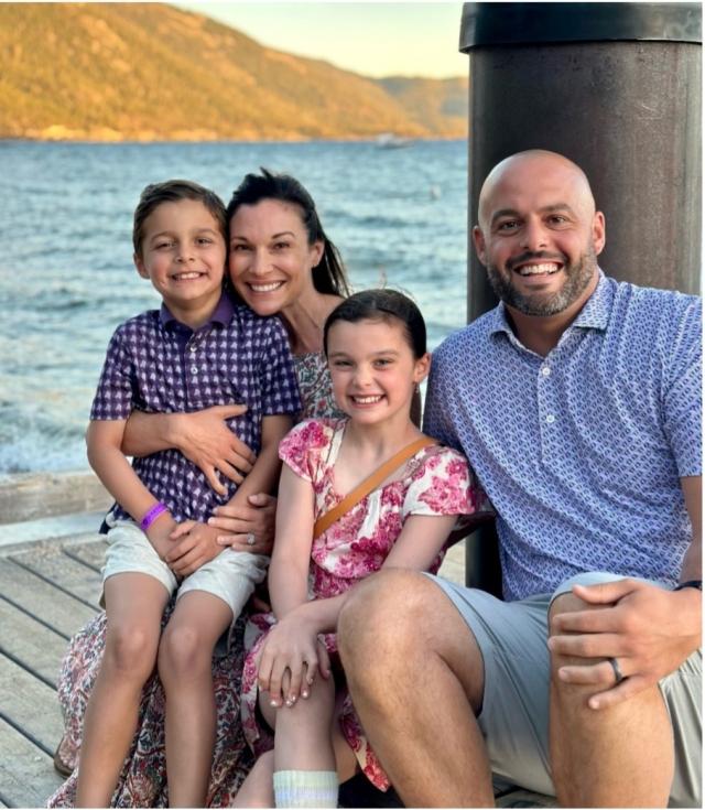 Nick, heather, and their two kids sitting on a dock