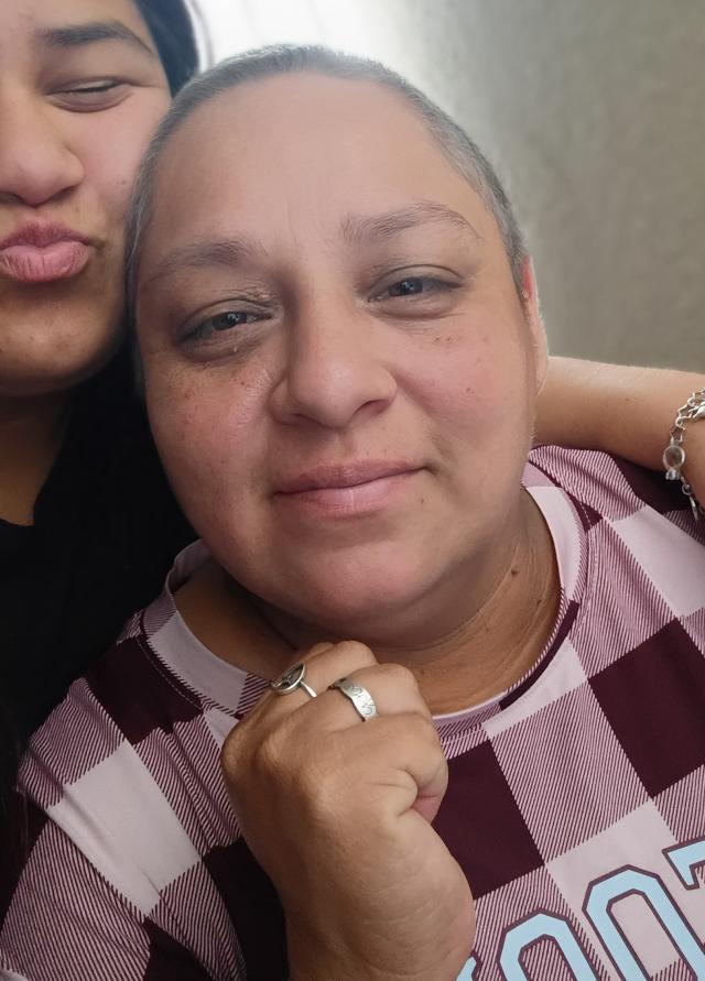 Sonya smiles with her daughter in the background