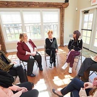 group of people sitting in a circle at a meeting