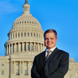 Gus Robertson smiles in front of the U.S. Capitol.