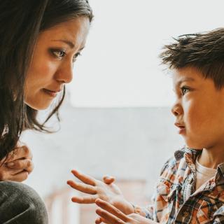A woman listens as a young boy talks
