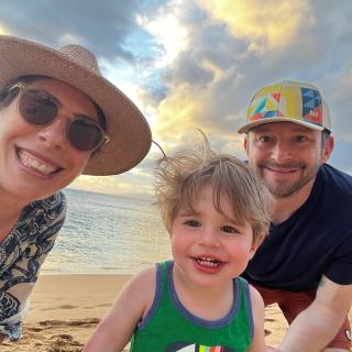 Jonathan and his family smile on a sandy beach