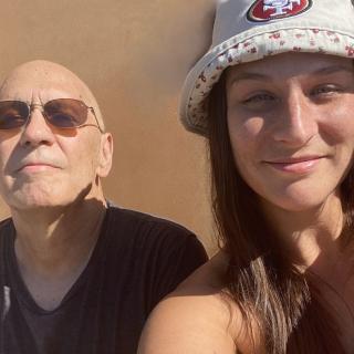 Jeffrey smiles with his daughter in a sunny location