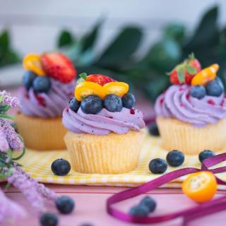 Cupcakes with purple icing and color fresh fruit toppings