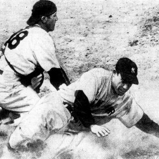 1950 black and white photo of catcher Phil Masi tagging Yogi Berra after sliding into base
