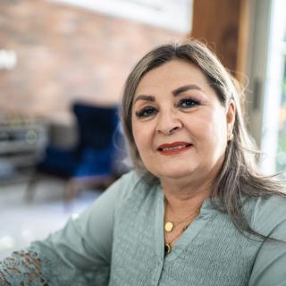 a woman sitting indoors smiling at the camera