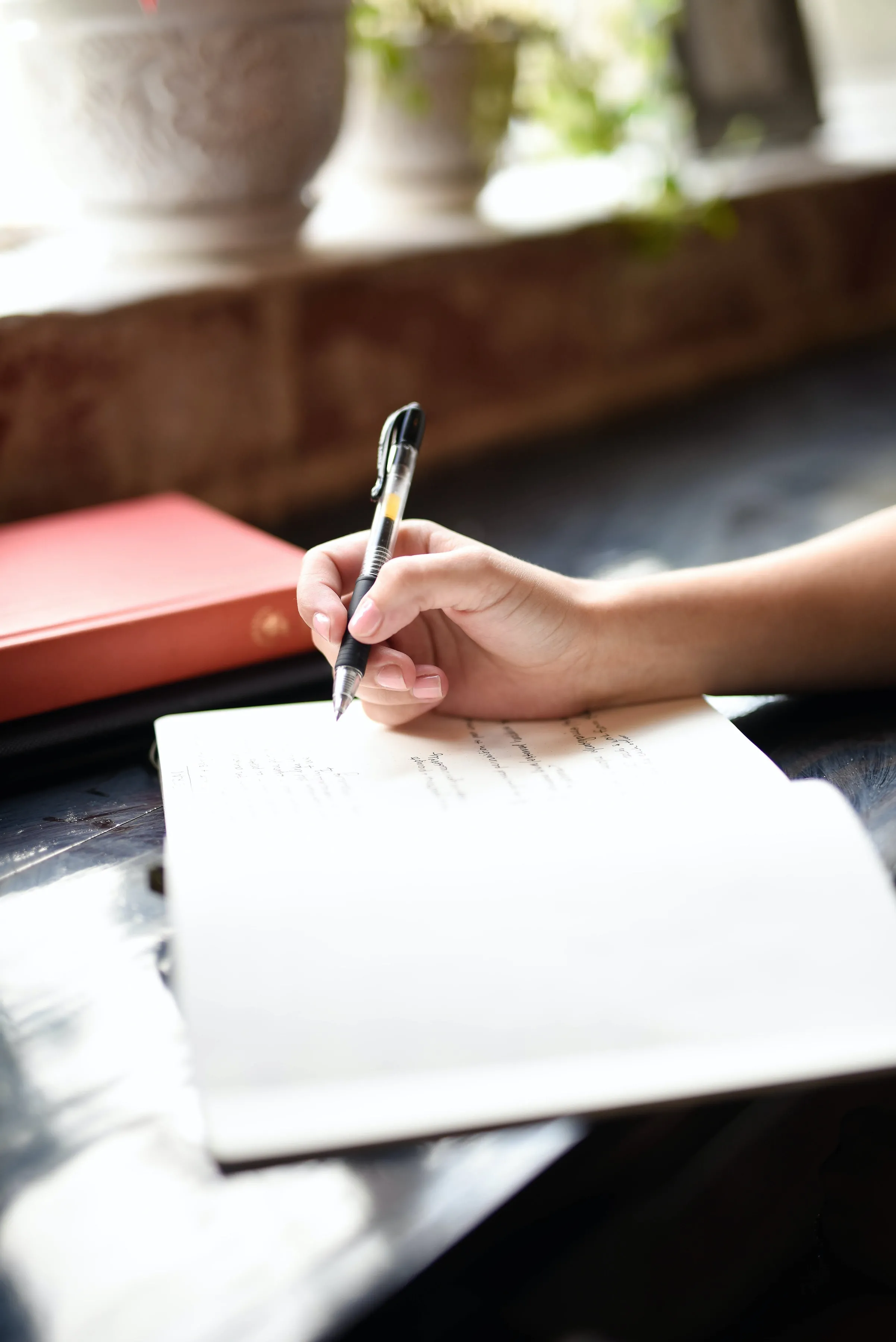 woman writing in a journal with a pen