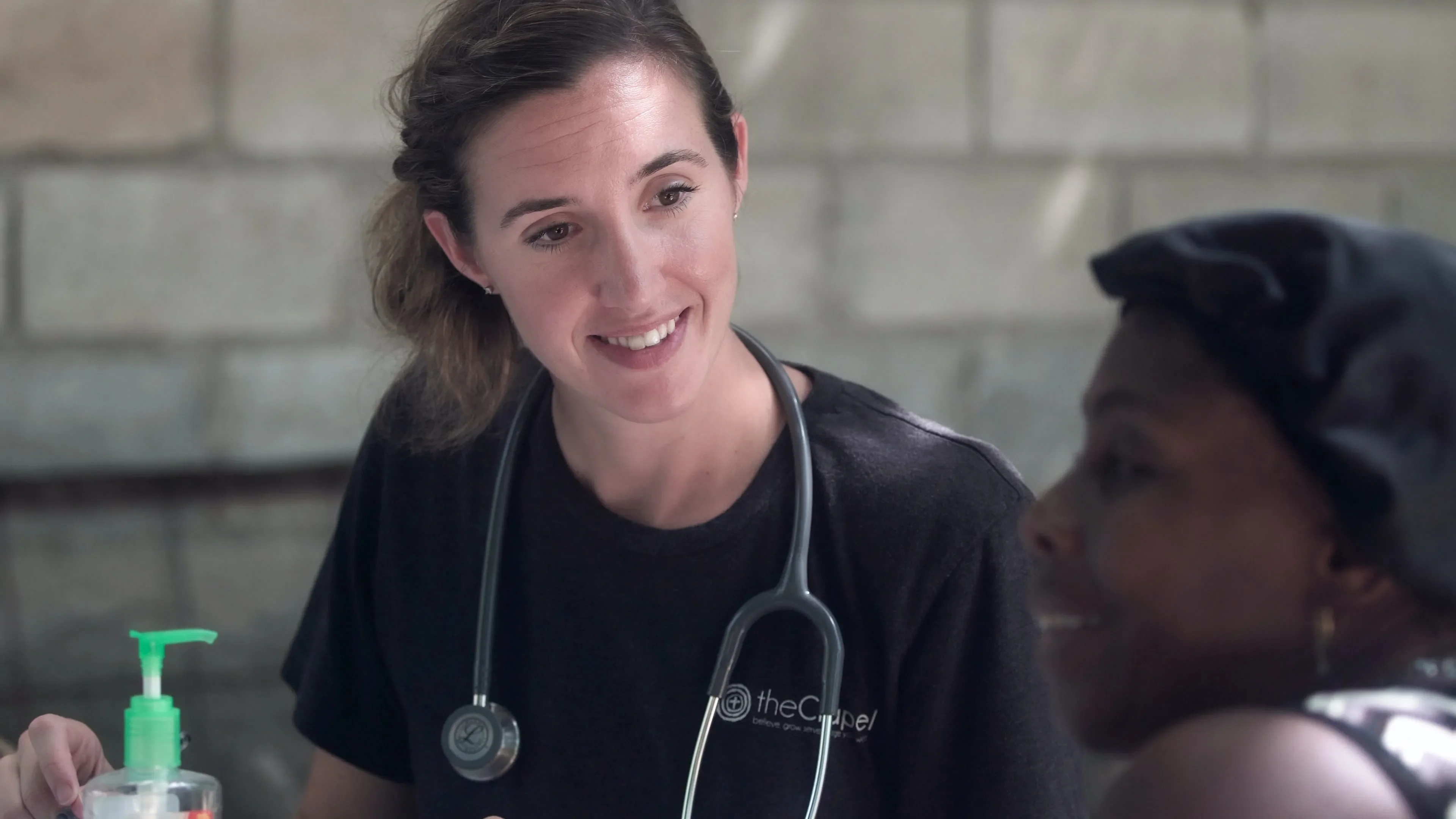 young white female nurse with black female patient