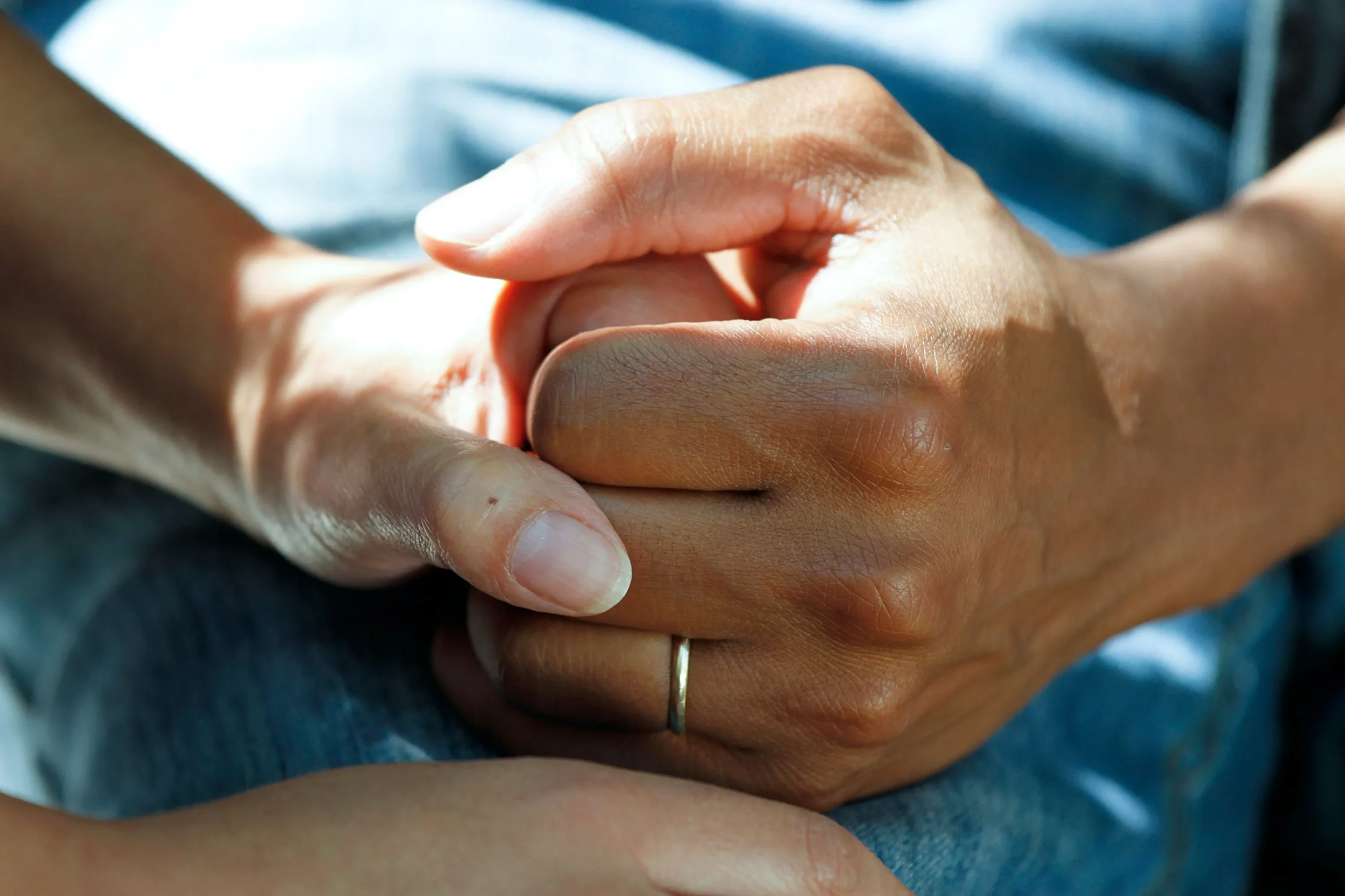 A husband and wife clasp hands to comfort each another