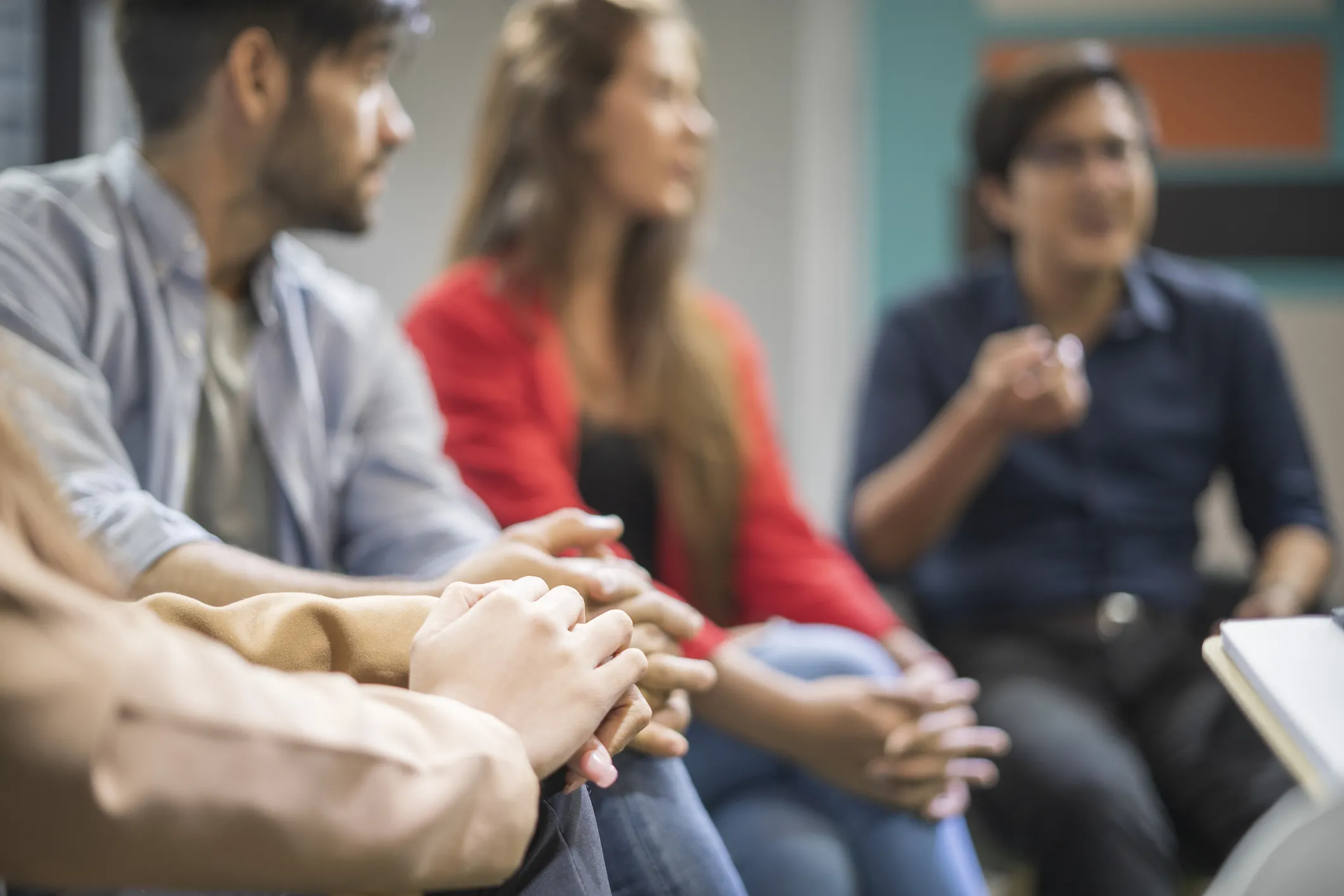 Young males and females are sharing ideas during group therapy
