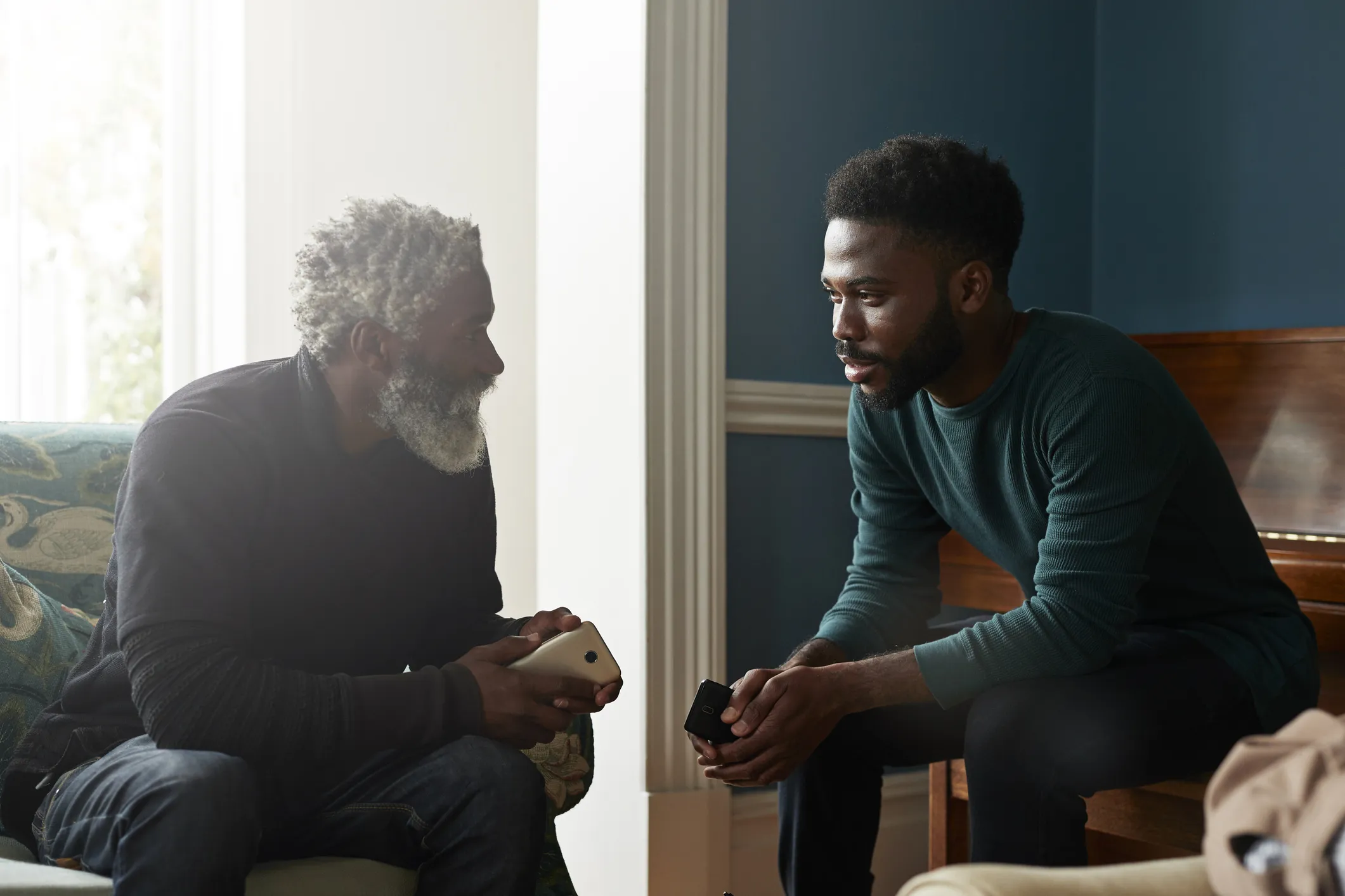 two seated black men talking