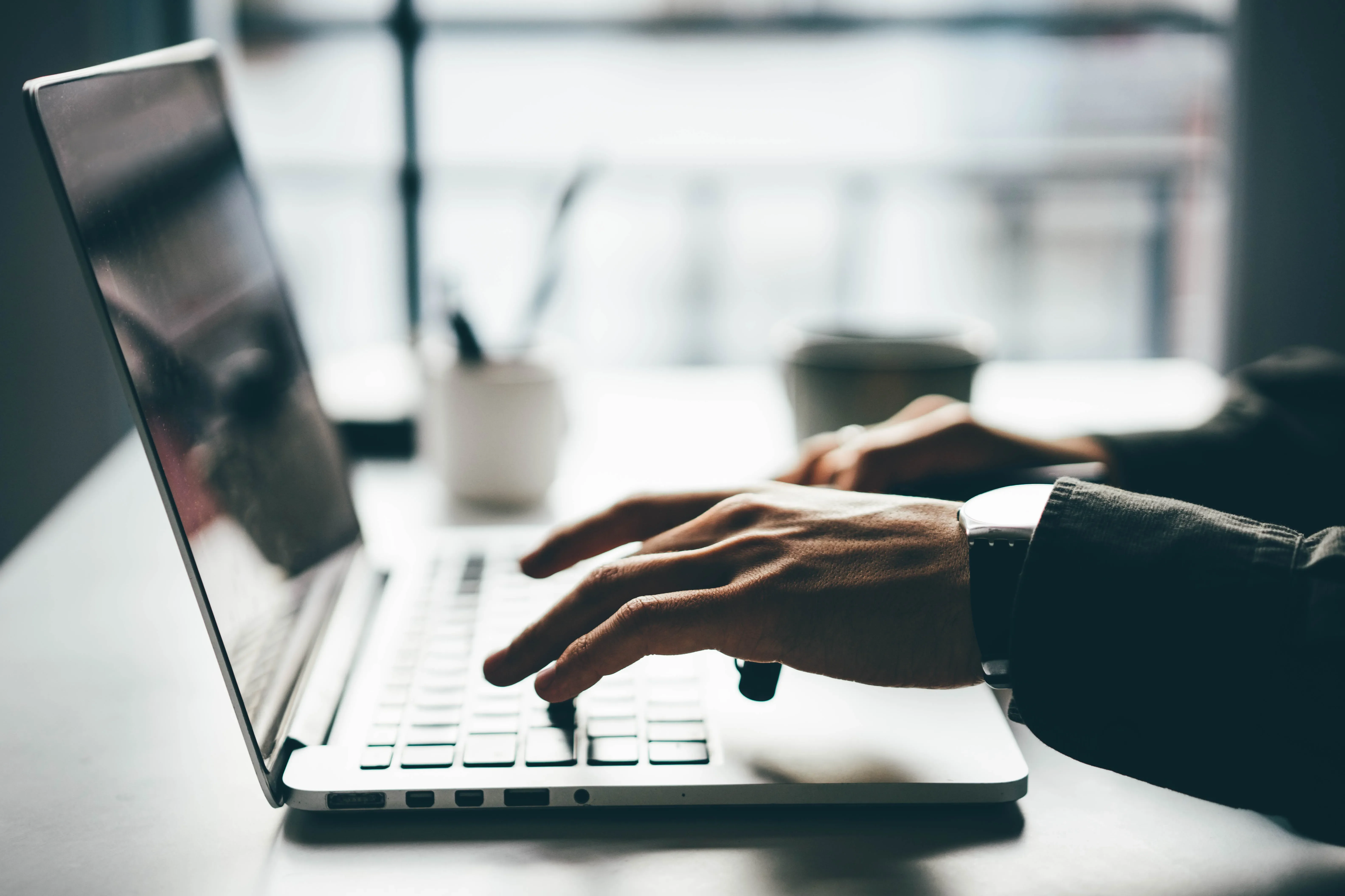 man's hands typing on keyboard