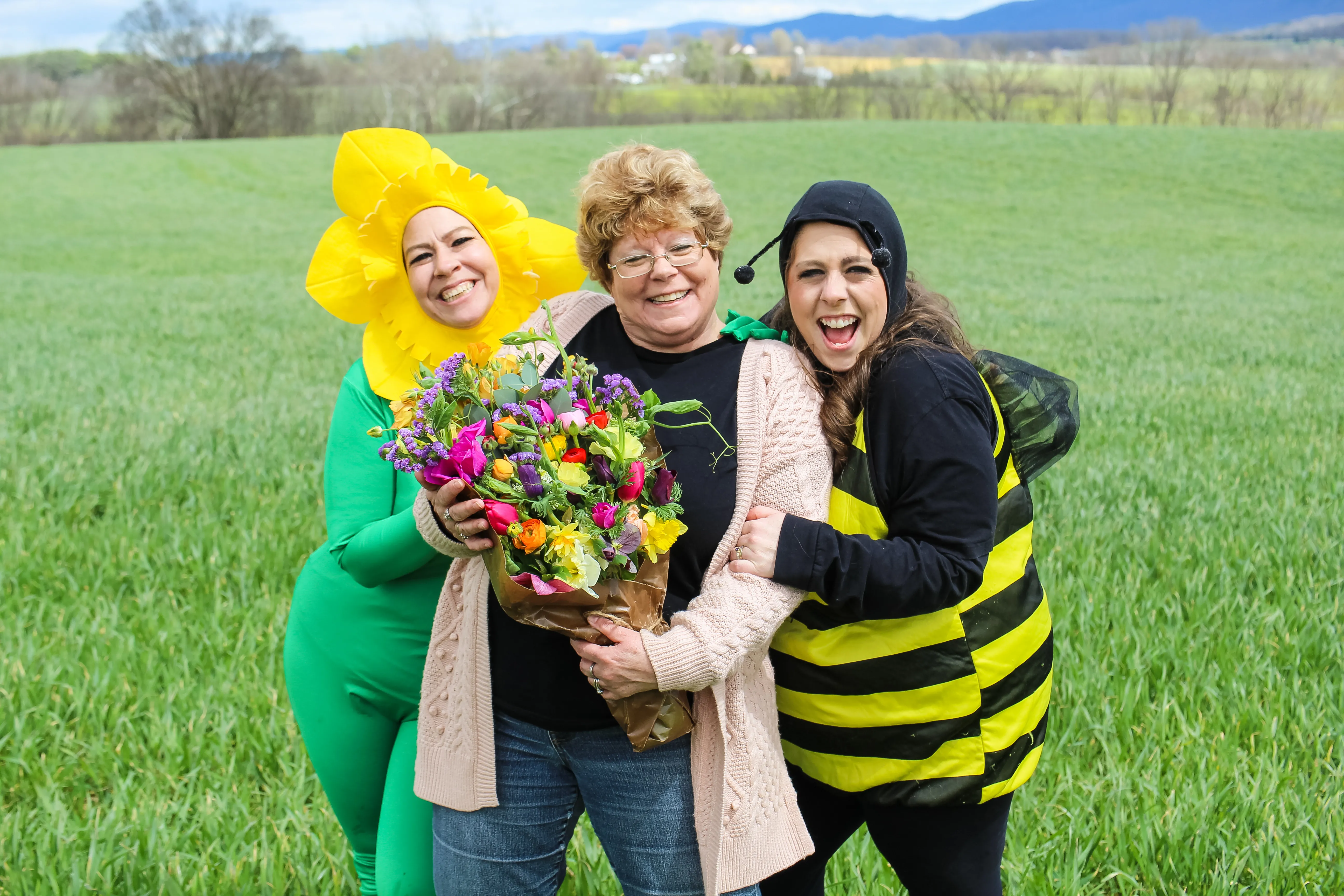 Harmony Harvest Farm owners smile and show off a farm-fresh flower bouquet