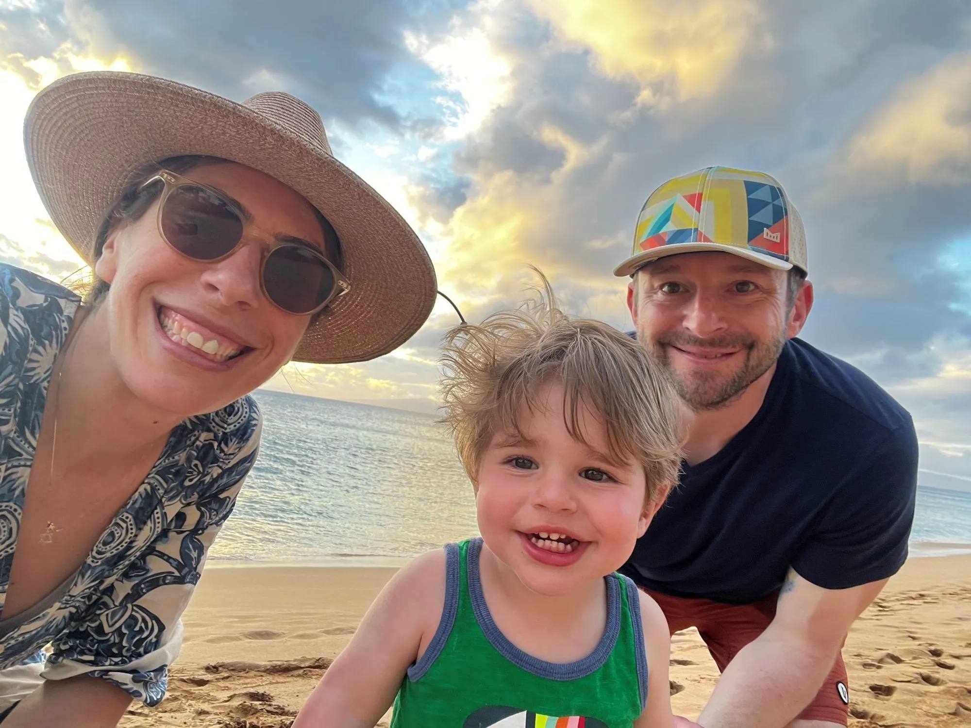 Jonathan and his family smile on a sandy beach