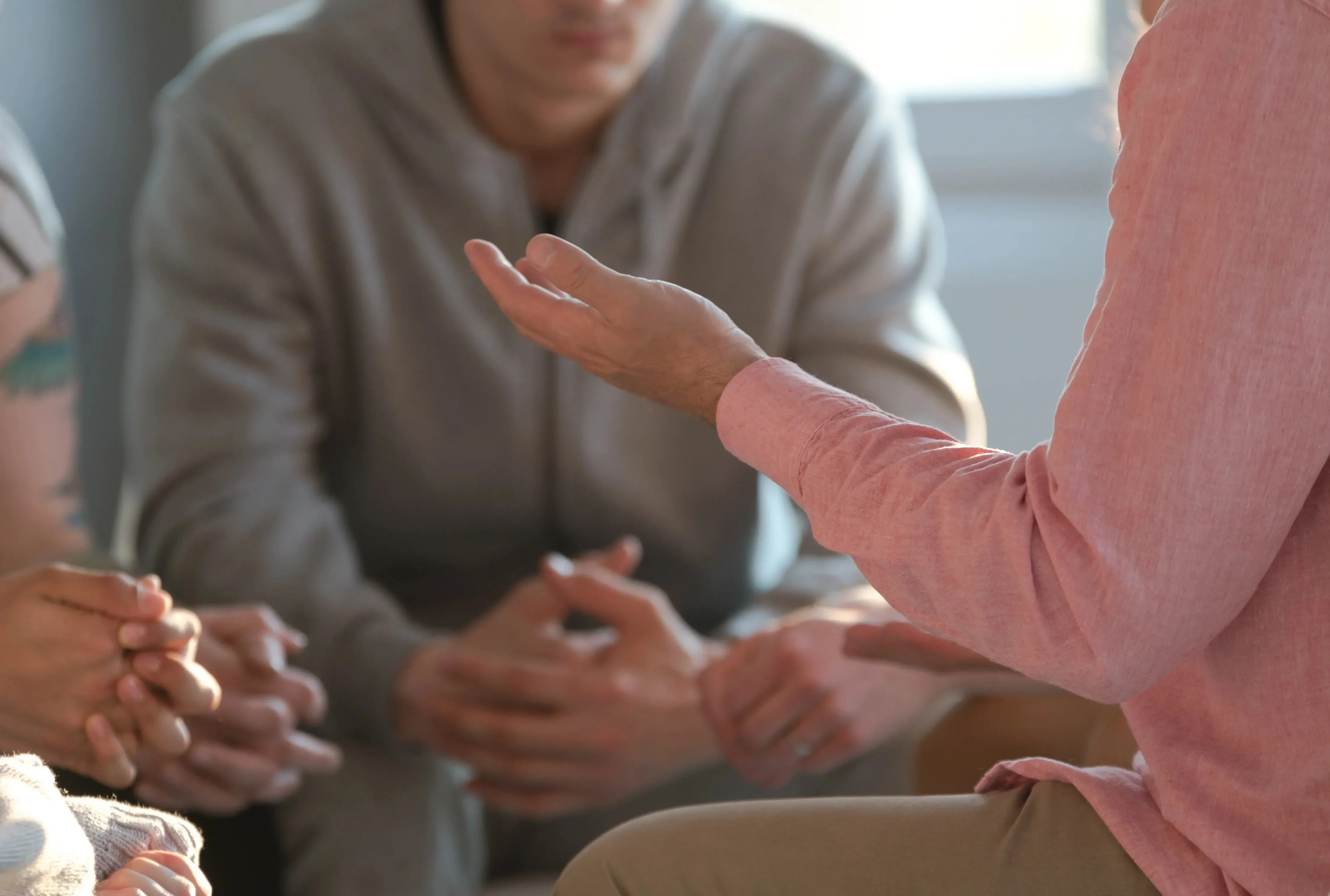 Two men sit in group talking