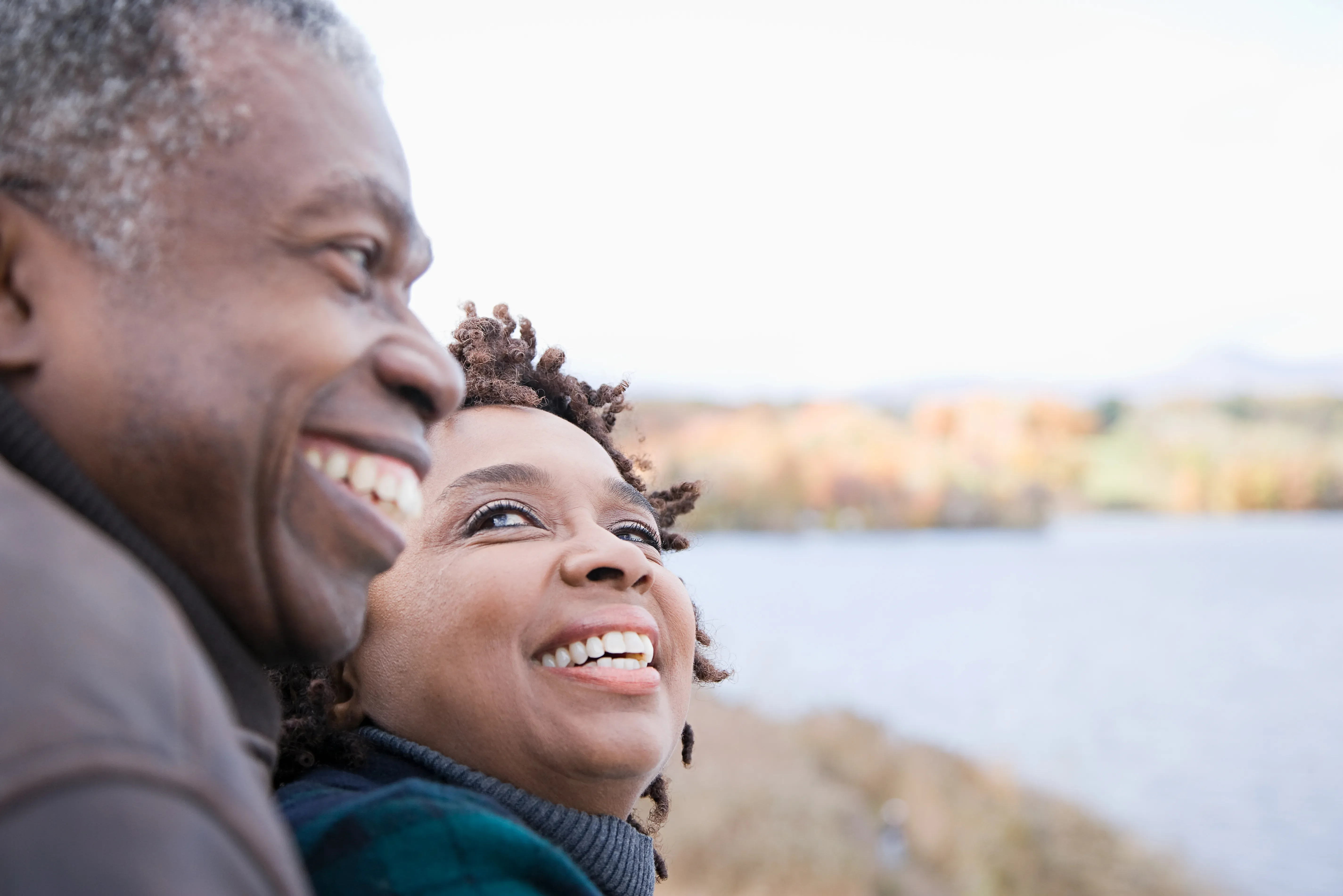 Man and woman smiling by pond