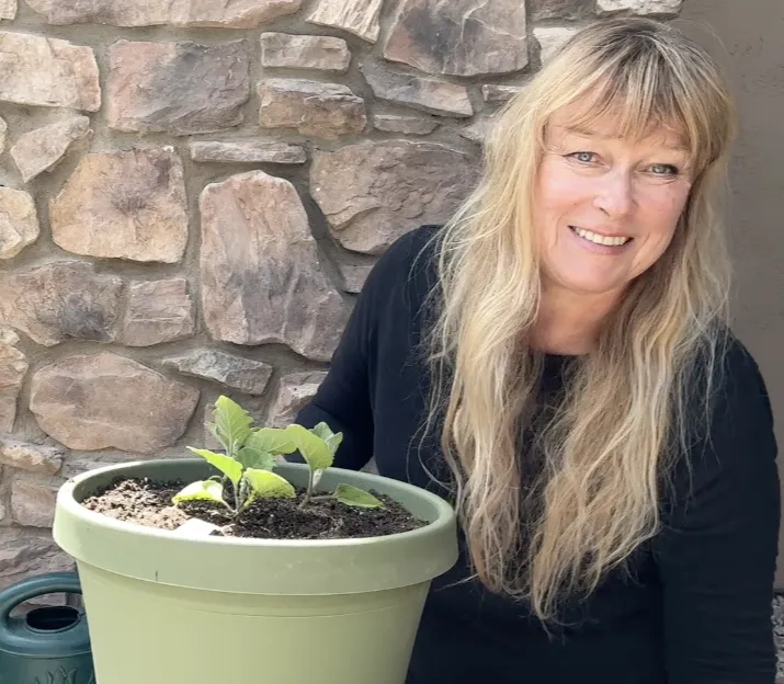 Siobhan Shaw poses next to a potted plant during filming for Growing To Give