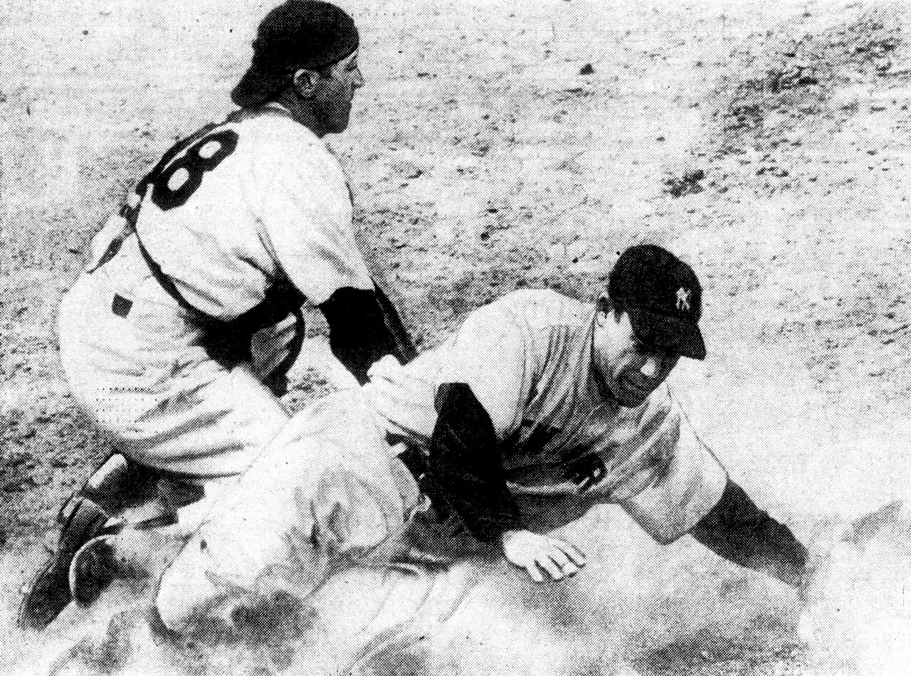 1950 black and white photo of catcher Phil Masi tagging Yogi Berra after sliding into base