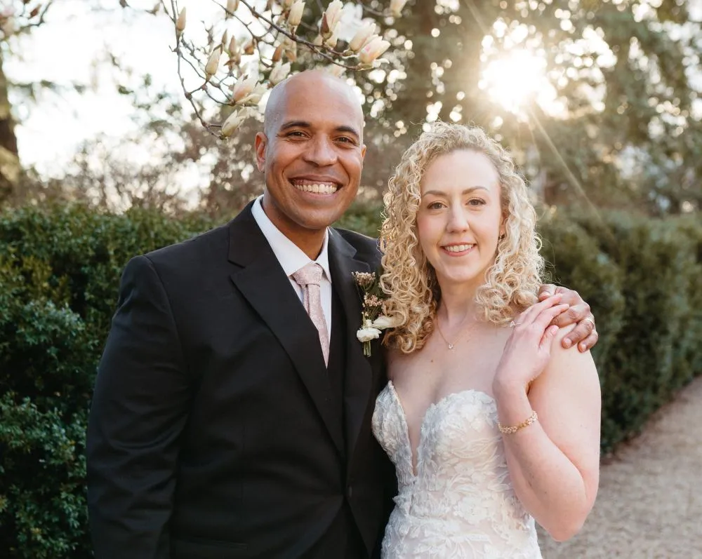 Brandon and Jackie on their wedding day beside a flowering tree