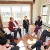 group of people sitting in a circle at a meeting