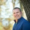 white man in blue fleece smiling outside