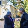 older white man and women talking outside in front of a house