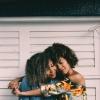 2 young black women embracing