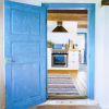 A kitchen beyond a bright blue door