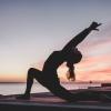 silhouette of a woman doing sunrise yoga 