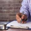 Doctor writing on clipboard