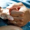 A husband and wife clasp hands to comfort each another