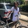 CSC's June Advocate Spotlight, Maria Brown, smiles while standing beside her bike outside