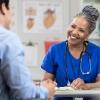 a smiling doctor sitting behind a table