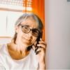 Elderly woman smiles as she talks on the phone