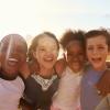 Four kids smiling in the sunset