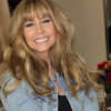 Wig designer and cancer hair loss consultant Amy Gibson wears a wig of long and wavy golden-brown hair