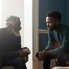 two seated black men talking