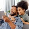 A couple on a couch looking at a tablet