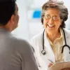 A happy smiling doctor reviews a file with a patient