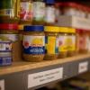 A shelf filled with jars of sunflower butter and cans of tuna