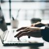 man's hands typing on keyboard