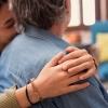 a woman lovingly hugs another person