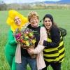 Harmony Harvest Farm owners smile and show off a farm-fresh flower bouquet