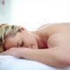 A woman rests on a massage table during an acupuncture session